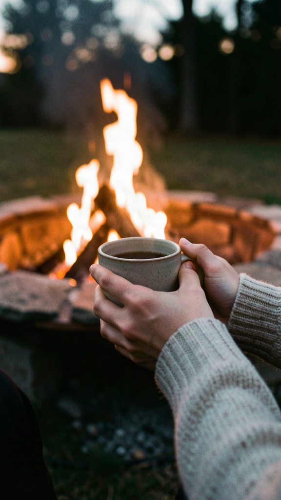 Warming hands with coffee by the fire pit